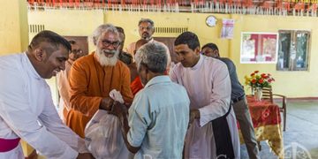 GFA (Gospel for Asia) founder and director Dr. K.P. Yohannan (center) helps distribute relief supplies in a predominantly Buddhist community while visiting Sri Lanka to see the organization’s ongoing relief efforts after severe flooding.
